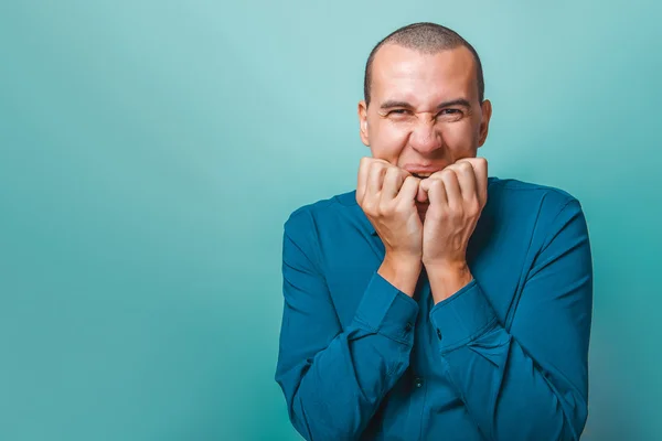 Een man van Europees uiterlijk dertig jaar vingernagels kauwen op — Stockfoto