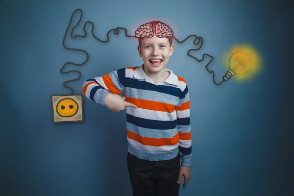 Boy shows his index finger down and laughs charging cord plug wi — Stock Fotó