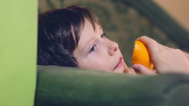 Jongen tiener is eten een oranje en peel — Stockvideo