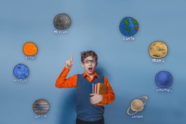 Teen boy in glasses shows a hand holding up the old books of the
