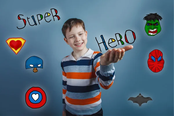 Boy smiling and holding his hand on the word superhero super pow — Stock fotografie