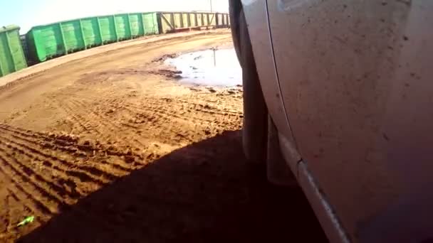 Car auto goes through puddles and mud sun glare on the water HD — Stock Video