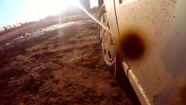 Car auto går igenom vattenpölar och lera solen reflexer på vatten Hd — Stockvideo