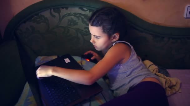 Девочка подросток играет ноутбук лежит на диване поиск в Интернете образ жизни компьютерная игра — стоковое видео