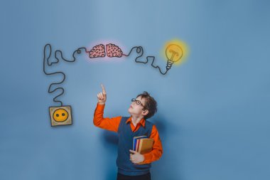 Teenage boy in glasses holding books showing thumb up charging c