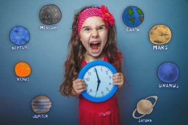 Teen girl gets angry and yells holding round the clock in the ha