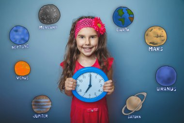 Teen girl laughs holding her hands round the clock blue planet o