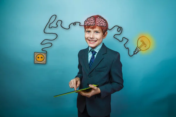 Teenage boy in suit smiling and working in the tablet charging c — Stock Fotó