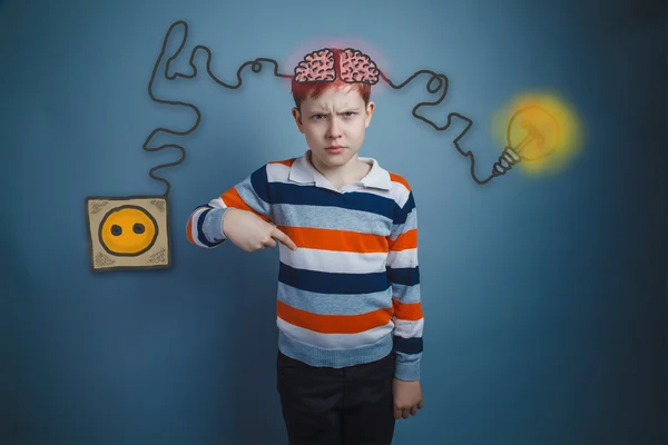 Teenage boy showing his index finger down and frowned face ignit — 图库照片