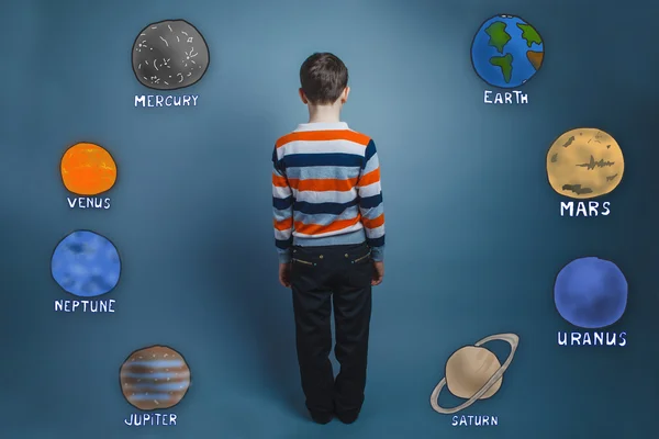 Хлопчик-підліток стоїть зі спиною планет Сонячної системи — стокове фото