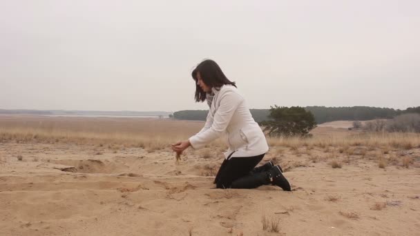 Fotografo scatta foto come una donna versa sabbia sulla natura autunno — Video Stock