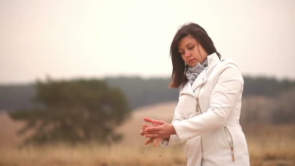 Mujer chica vierte arena símbolo tiempo otoño frío — Vídeos de Stock