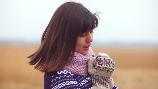Portrét ženy dívka v svetr šála a palčáky na podzimní přírody chladné suché trávy — Stock video