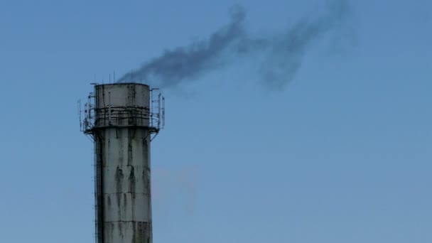 Трубный завод закрыть черный дым против голубого неба — стоковое видео