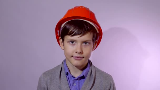 Teen Boy Baumeister in orangefarbenem Helm Studioporträt — Stockvideo