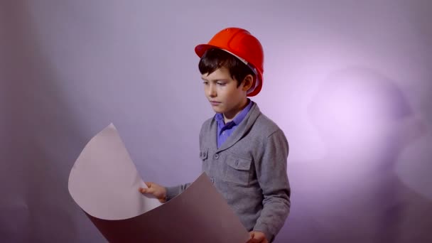 Teen boy builder in casco in possesso di documenti piano di costruzione — Video Stock