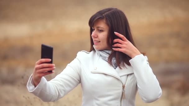 Kvinna tjej smartphone gör själv telefonen sitter på torra träd natur hösten — Stockvideo
