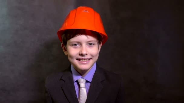 Teen stående pojke builder i hjälm leende — Stockvideo
