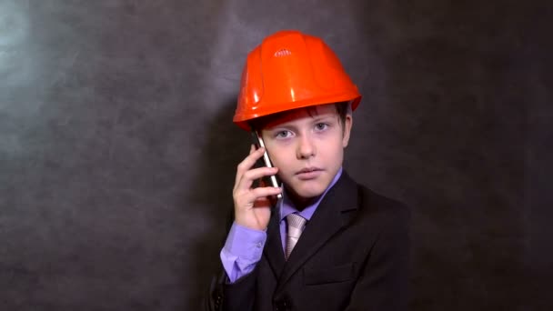 Adolescente retrato menino construtor no capacete sorrindo falando no telefone smartphone — Vídeo de Stock