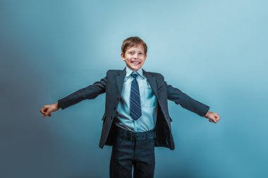 Teen boy of twelve European appearance in a business suit his ar