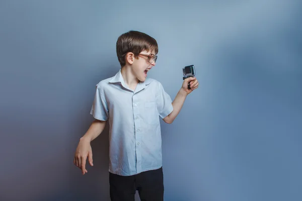 A boy of twelve European appearance in sunglasses holding a came — 图库照片