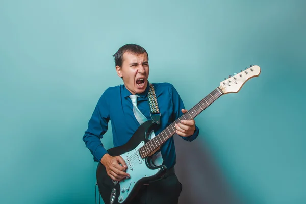 A man of European appearance thirty years of playing the guitar — Stock Photo, Image