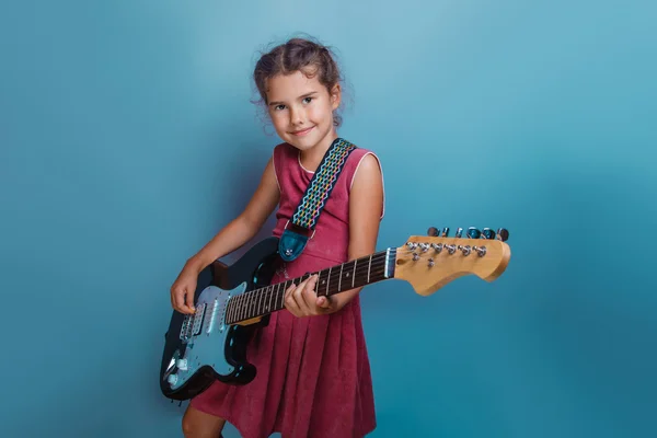 Chica aspecto europeo diez años tocando la guitarra en un bac azul — Foto de Stock