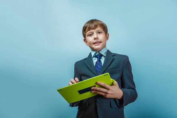 Teen  boy of twelve European appearance in a business suit holdi — Zdjęcie stockowe