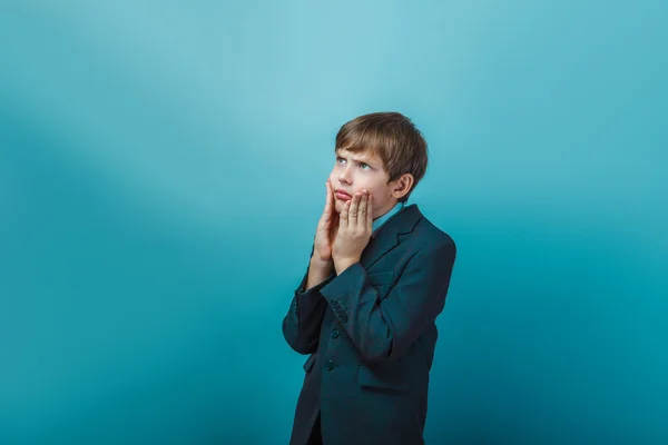 Teen boy of twelve European appearance in a business suit holdin — ストック写真