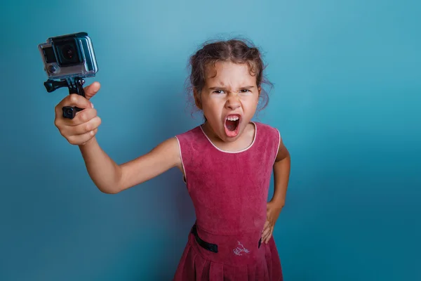 Teen girl of European appearance seven years, holding the camera — Stok fotoğraf