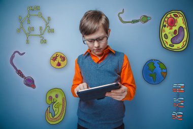 Teenage boy in glasses enthusiastically working on the tablet to