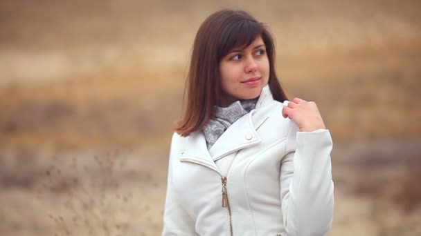 Mujer chica en otoño abrigo en la naturaleza del viento está soplando fondo marrón — Vídeos de Stock