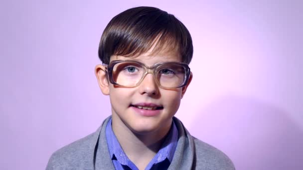 Portret jongen tiener schooljongen nerd bril op paarse achtergrond onderwijs — Stockvideo