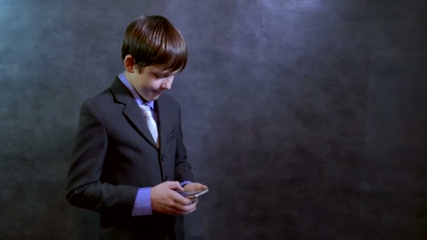 ソーシャル メディアのネットワーク インターネット上のスマート フォン検索を保持している十代の少年実業家 — ストック動画