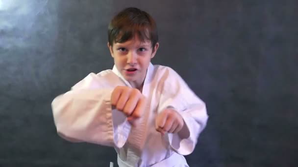 Tizenéves fiú, karate kimonó küzdelem kézzel integetett ököllel lassú mozgás — Stock videók