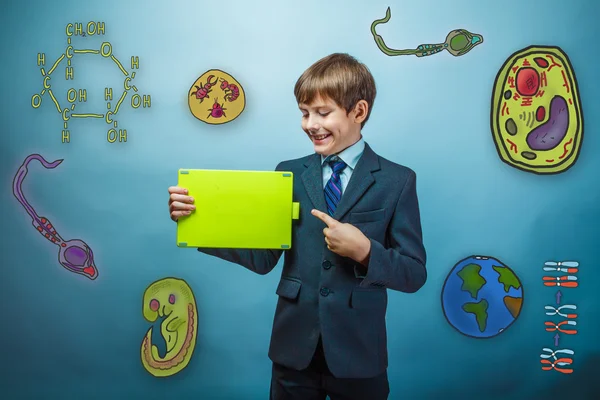 Teen boy businessman points his finger to the tablet and smiles — Stock Fotó