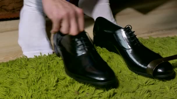 Uomo in calzini bianchi vestito scarpe per legare lacci delle scarpe — Video Stock