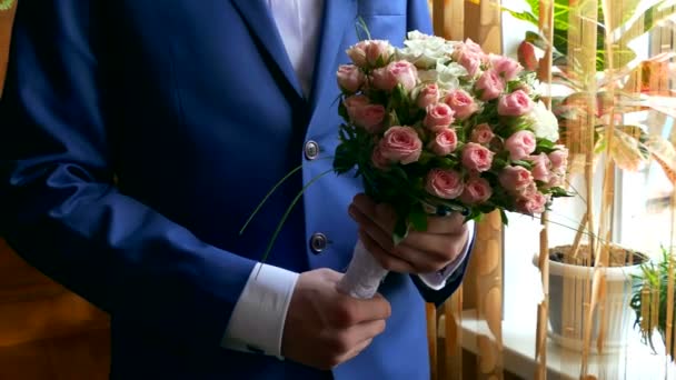 Man groom lifts bridal bouquet at a wedding table accessories — Stock Video