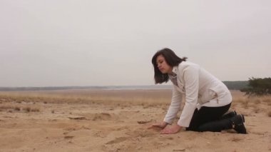 kadın kız diz çöker ve kum sonbahar doğa soğuk atar