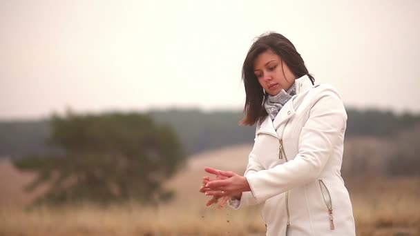 Chica mujer vierte arena tiempo símbolo otoño frío blanco fondo — Vídeos de Stock