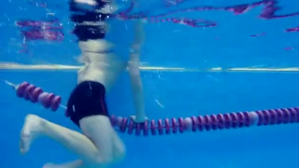 Teen šťastný chlapec plavání v bazénu ponory pod vodou — Stock video