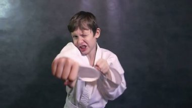 çocuk genç karate yumruk yavaş hareket sallayarak kimono mücadele elinde