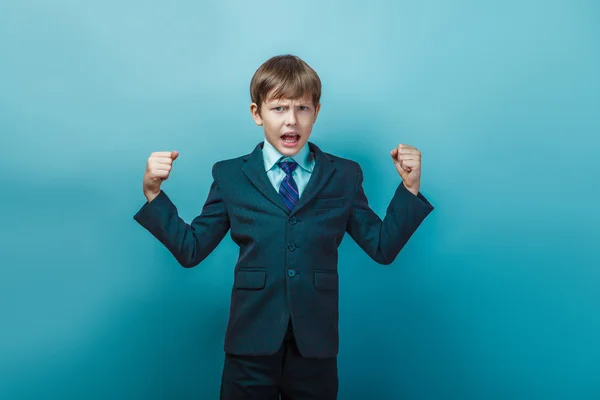 A boy of  twelve European appearance  in a suit shouting angry o — стокове фото