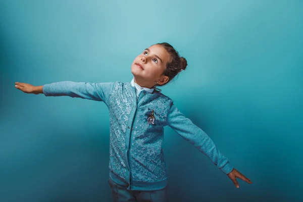 Teenie-Mädchen sieben Jahre zeigt eine fliegende Hand auf einem grauen Hintergrund — Stockfoto