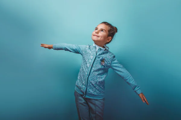 Teen girl  seven years shows a flying  hands on a gray backgroun — ストック写真