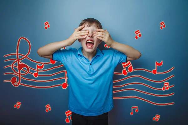 Adolescent boy screaming with his eyes closed hands music notes — Stockfoto
