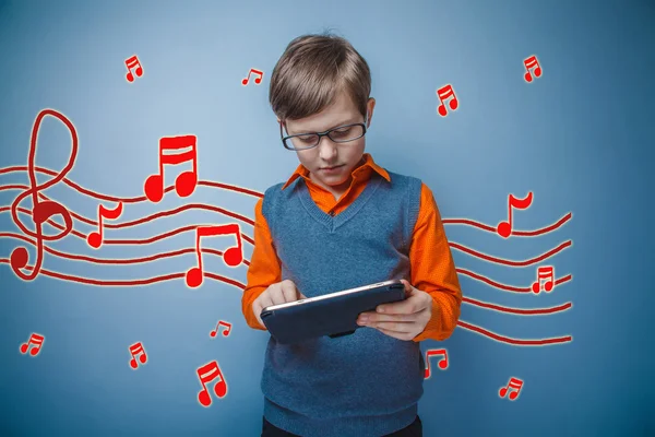 Adolescent boy working on a tablet retro music notes sketch prev — Zdjęcie stockowe