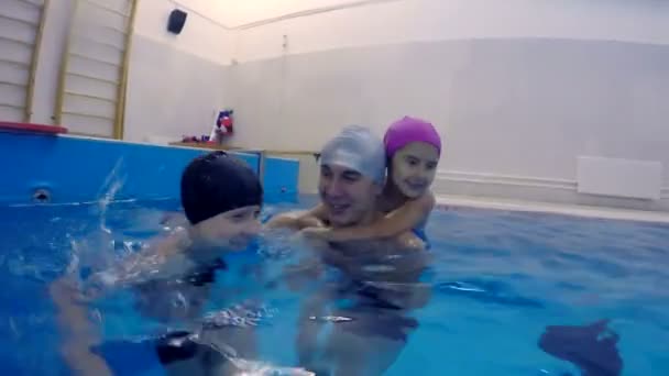 Heureux père de famille et les enfants dans la piscine sauter dans la joie de l'eau — Video