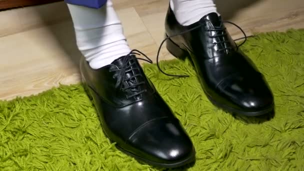 Mens in witte jurk sokken te binden schoenveters schoenen — Stockvideo