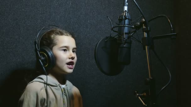 Flicka tonåring i hörlurar sjunga i mikrofon inspelningsstudio — Stockvideo